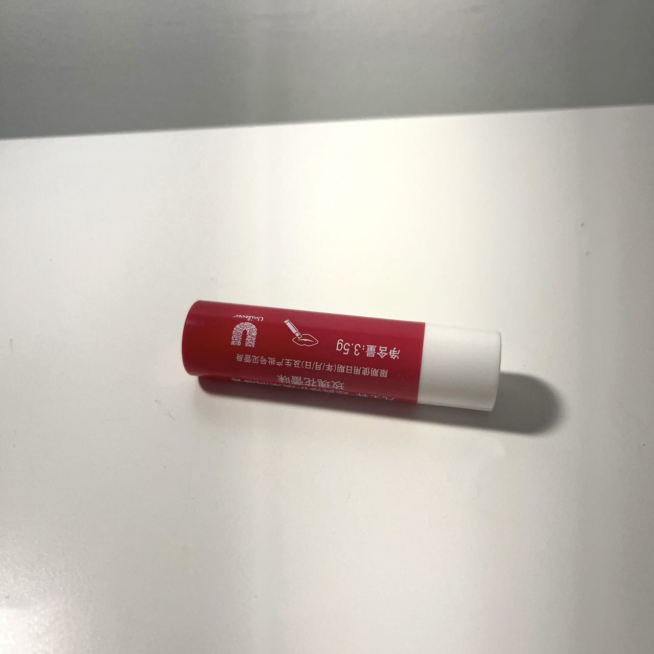 Cylindrical lipstick lying horizontally on the table